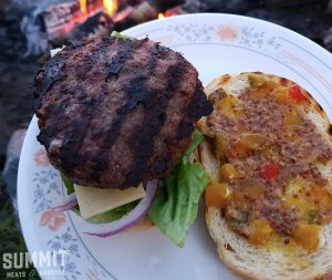 Photo of a burger from Summit Meats in Saskatoon after being cooked over a campfire